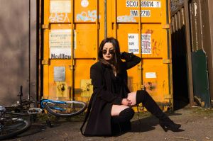Model knelt in front a yellow container