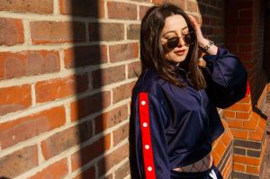 Close up portrait of model with sunglasses against a brick wall
