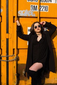Portrait of model stood in front of yellow storage container
