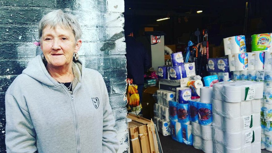 Old lady in hoodie out side thrift shop in shoreditch