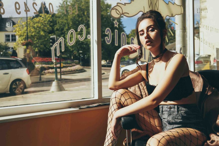 fed up model sat in front of a big window in vintage tones