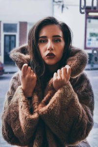 Close up portrait with brown haired model in a fur coat