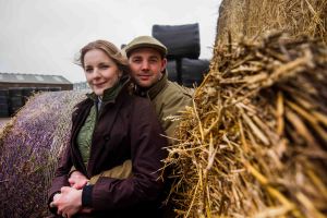 On the farm couple portrait cuddling next to the hay