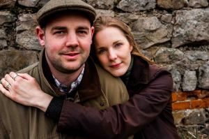 Close up couple portrait of farmer husband and wife with rock wall background