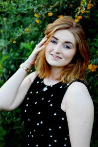 Springtime portrait of fair skinned model with green foliage and yellow flowers