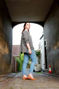 Lifestyle full length portrait of hipster woman walking through a model