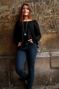 Urban portrait of female model leaning against an urban wall