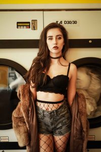 Brown haired model in front of washing machines