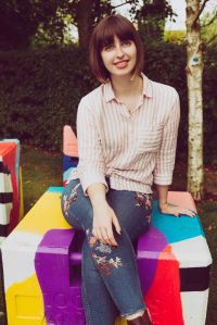 Portrait photo of Life of lilly sat on a multi coloured box