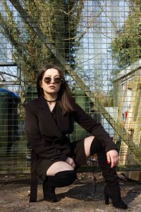 Urban portrait of model in front of fence
