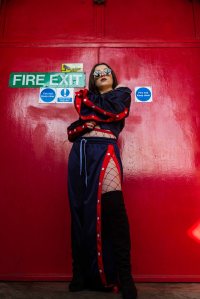 Fashion editorial portrait of model in front of a red fire door