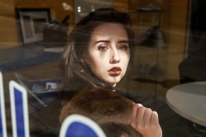 Brown haired model shot through reflective glass