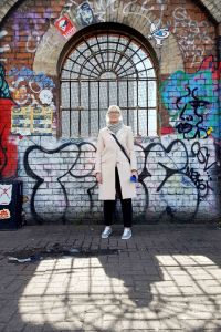 Full length portrait in front of a graffiti wall and window