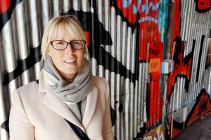 Street portrait of woman against graffiti wall