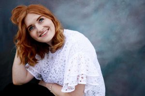 Ginger haired model laughing with grey background