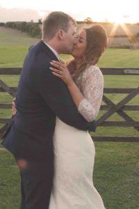 wedding sunset portrait with bride and groom kissing