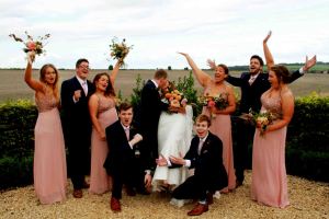 bride and groom kissing while friends cheer
