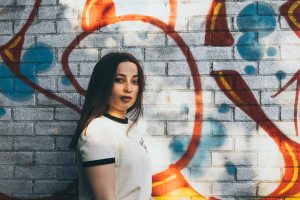 Natural light portrait of model in front of graffiti wall