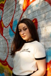 Close up portrait of model against red and silver graffiti wall