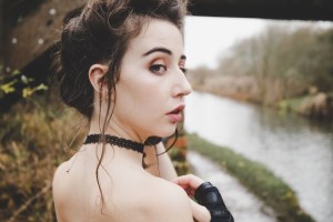 Brunette portrait of model looking over her shoulder with river behind
